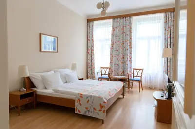 a living room with a blue chair and a blue couch at Hotel Orion in Prague