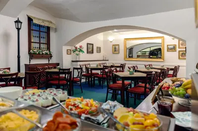a restaurant with tables and chairs with food on display at Hotel Orion in Prague