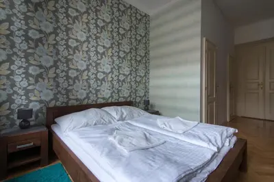 a bedroom with a bed with white sheets and a floral wallpaper at Great place near city centre in Prague