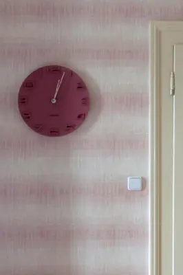 a clock hanging on a wall next to a door at Great place near city centre in Prague