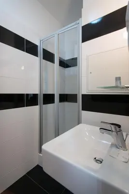 a white bathroom with a sink and a shower at Great place near city centre in Prague