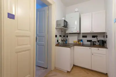 a kitchen with white cabinets and a white door at Great place near city centre in Prague