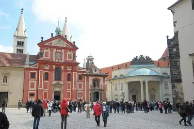 a large group of people walking around a building at Císařka Apartments in Prague