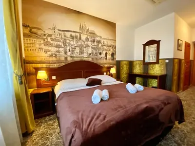 a bedroom with a large bed with white slippers on it at SPA Hotel Liliova Prague Old Town in Prague