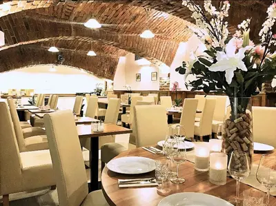 a restaurant with tables and chairs and a vase of flowers at SPA Hotel Liliova Prague Old Town in Prague