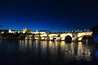 a bridge over a river with a city in the background at SPA Hotel Liliova Prague Old Town in Prague