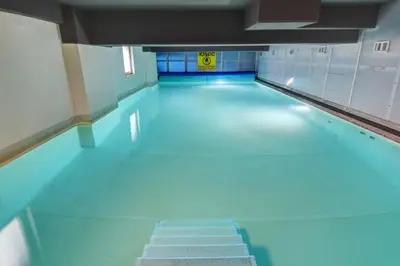 an empty swimming pool with blue floors and a sign on the wall at Plus Prague in Prague