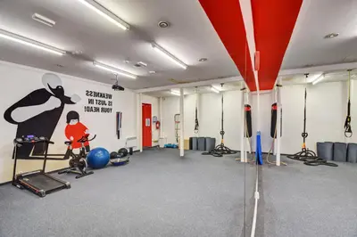 a gym with a man on a bike and a painting on the wall at Plus Prague in Prague