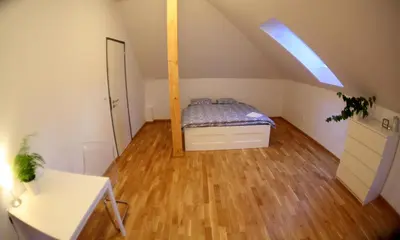 a attic room with a bed and a desk at Sport Pension Cibulka in Prague