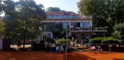 a building with people playing tennis on a tennis court at Sport Pension Cibulka in Prague
