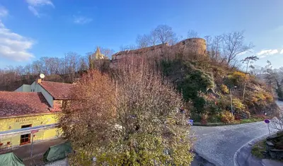 a castle on the side of a hill at Hotel Sýkora in Křivoklát