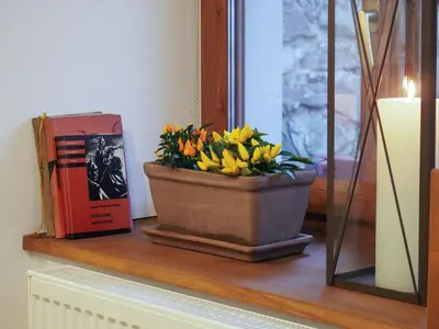 a vase of flowers on a shelf next to a book at Hotel Sýkora in Křivoklát