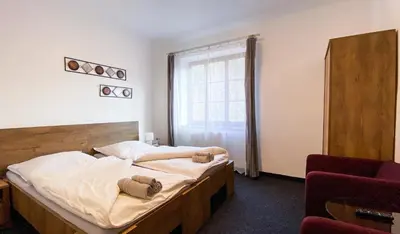 a bedroom with a large bed and a window at Hotel Sýkora in Křivoklát