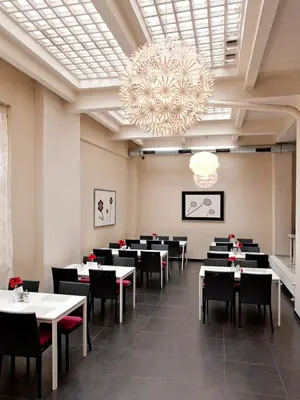 a dining room with tables and chairs and a chandelier at Hotel PurPur in Prague