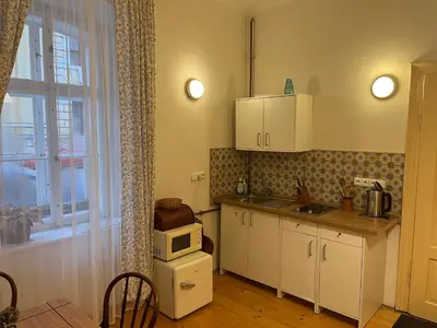 a kitchen with white cabinets and a microwave at Apartment Žižkova 159, Terezín in Terezín