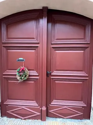 a red door with a wreath on it at Apartment Žižkova 159, Terezín in Terezín