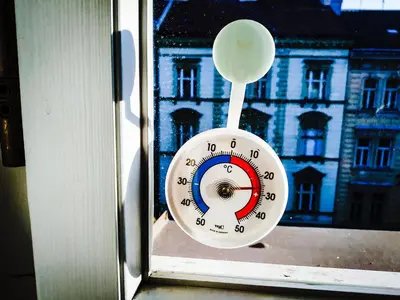 a clock sitting in a window with a view of a building at LOVELY Prague Apartment in Prague