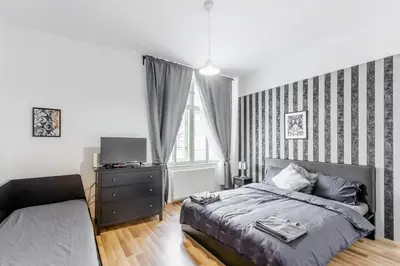 a bedroom with a bed and a dresser and a window at Old Strand Spirit in Prague