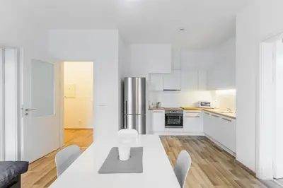 a white kitchen with a table and chairs at Old Strand Spirit in Prague