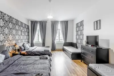a bedroom with two beds and a tv and a couch at Old Strand Spirit in Prague