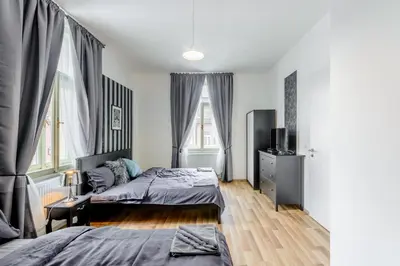 a bedroom with two beds and two windows at Riverside SPIRIT in Prague