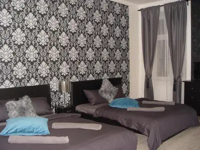 a bedroom with two beds in front of a wallpaper at Riverside SPIRIT in Prague