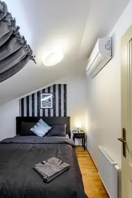 a bedroom with a bed with a black headboard at Riverside SPIRIT in Prague