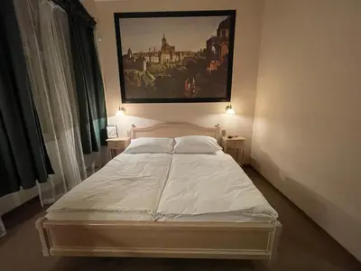 a bed in a bedroom with a painting on the wall at U Cervene zidle - Red Chair Hotel in Prague