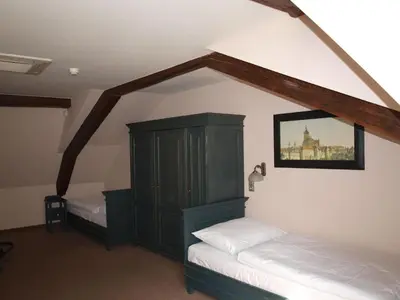 a bedroom with two beds and a cabinet in a room at U Cervene zidle - Red Chair Hotel in Prague