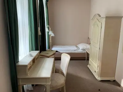 a room with a desk and a bed and a window at U Cervene zidle - Red Chair Hotel in Prague