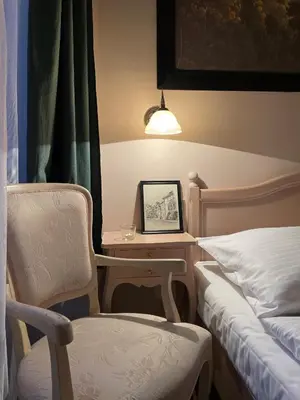 a bedroom with a desk and a chair next to a bed at U Cervene zidle - Red Chair Hotel in Prague