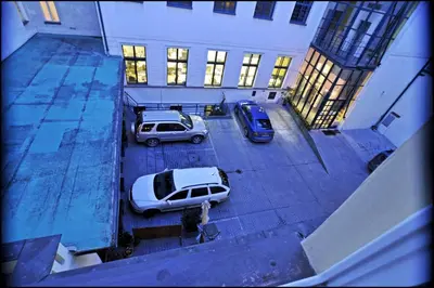 two cars parked in a parking lot in a building at U Cervene zidle - Red Chair Hotel in Prague