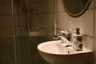 a bathroom sink with a shower and a mirror at Penzion U Kapra in Roudnice nad Labem