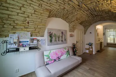 a living room with a couch and a stone wall at Penzion U Zámku in Mělník
