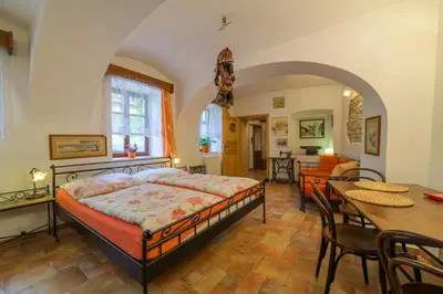 a bedroom with a bed and a dining room at Penzion U Zámku in Mělník