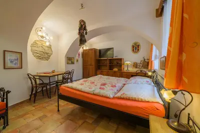 a bedroom with a bed and a dining table at Penzion U Zámku in Mělník