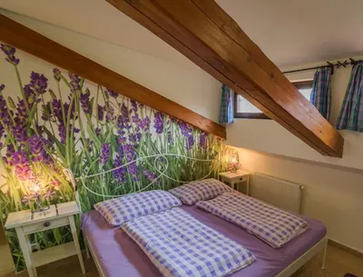 a bedroom with a bed and flowers on the wall at Penzion U Zámku in Mělník