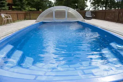 a blue swimming pool with a cover in a backyard at Resort Hulín in Sedlčany