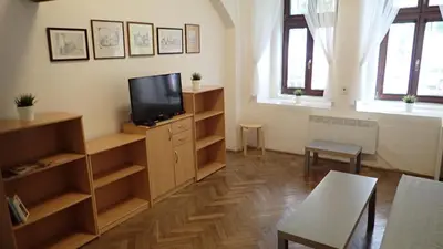 a living room with a flat screen tv and a table at Apartment Jackie in Prague