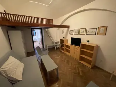 a living room with a couch and a desk with a television at Apartment Jackie in Prague