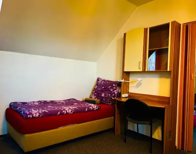 a bedroom with a bed and a desk and a chair at Penzion Chaloupka in Prague