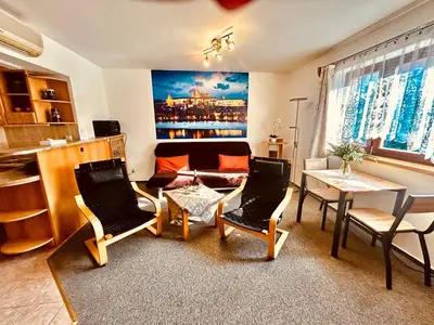 a living room with a couch and a table and chairs at Penzion Chaloupka in Prague