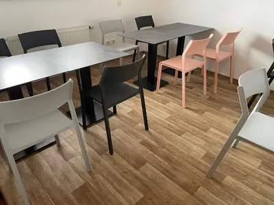 a dining room with tables and chairs and wooden floors at Hostel Little Quarter in Prague