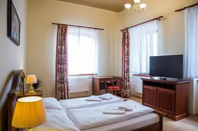 a bedroom with a bed and a desk and a television at Hostel Little Quarter in Prague
