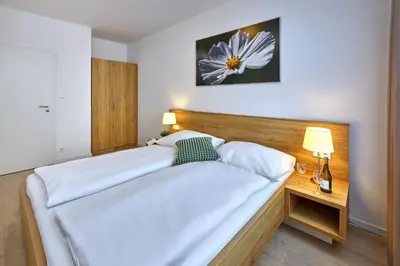 a bedroom with two white beds and a wooden headboard at CityWest Apartments in Prague