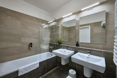 a bathroom with two sinks and a mirror at CityWest Apartments in Prague