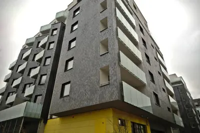 a tall gray building with a yellow door at CityWest Apartments in Prague