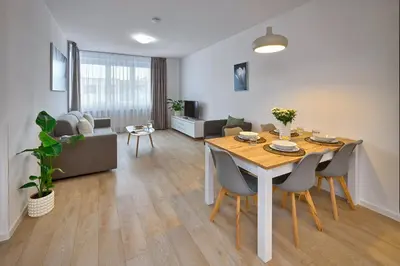 a dining room and living room with a table and chairs at CityWest Apartments in Prague