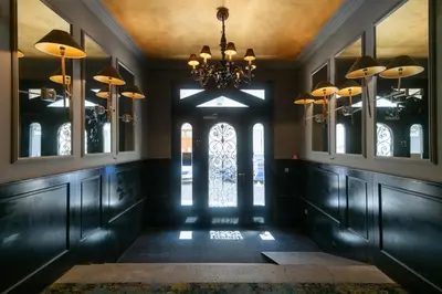 a hallway with a chandelier and a room with windows at Numa Prague Root in Prague