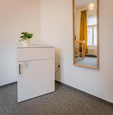 a bathroom with a mirror and a white refrigerator at Self-service Hotel Ostaš Praha in Prague